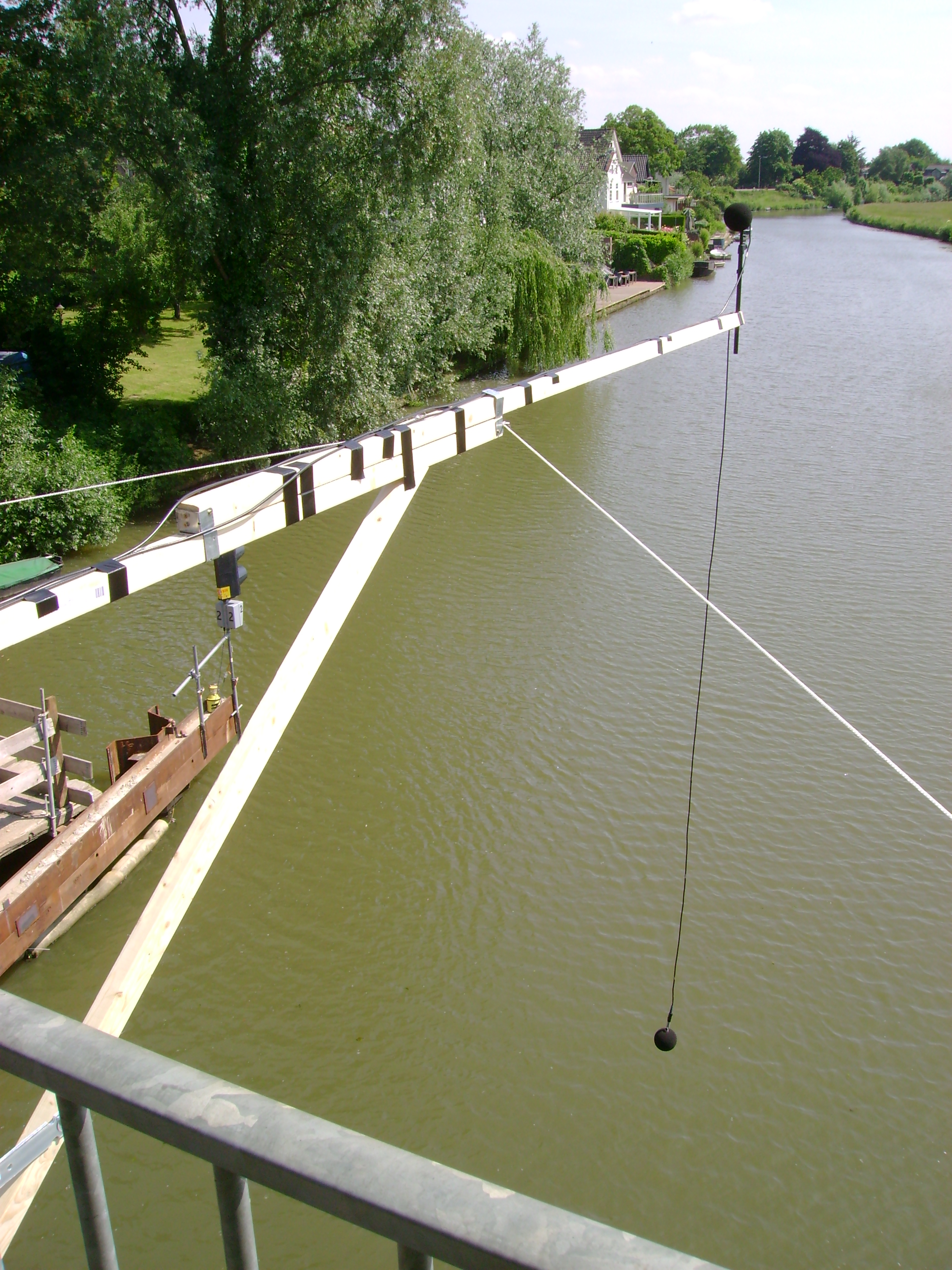 hekje met microfoon boven water uitgeklapt vanaf een brug